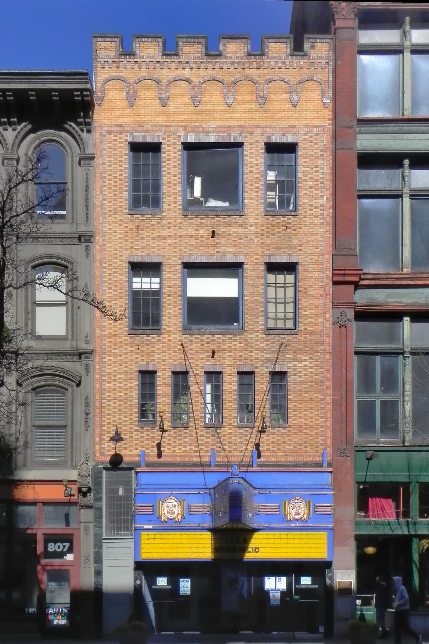 The Harris Theater on Liberty Avenue in Pittsburgh in 2025, a narrow street-front cinema with a vertical illuminated sign reading Harris.